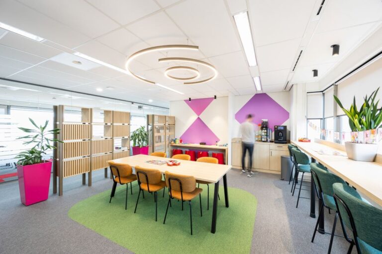 Gezellige kantoorruimte met vergadertafel, lockers en koffiehoek